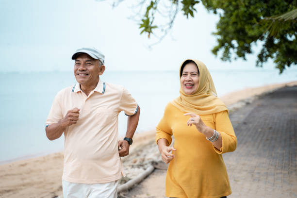 мусульманская зрелая пара делает бег трусцой вместе - aging process morning outdoors horizontal стоковые фото и изображения
