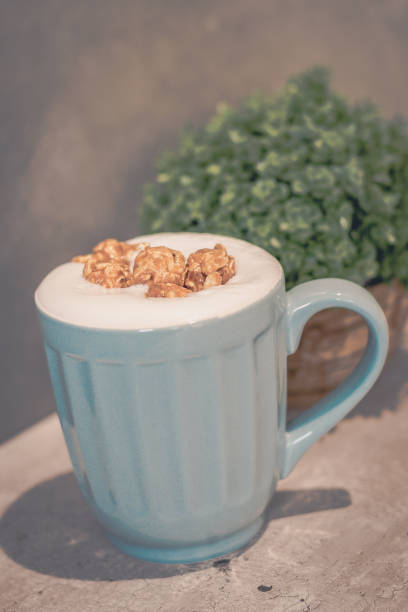 Caramel Popcorn Latte (no caffeine) in light blue mug and potted plant