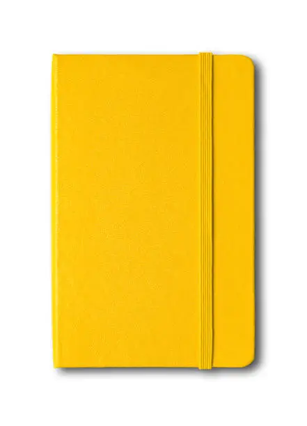 Photo of Yellow closed notebook isolated on white