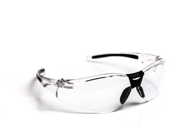 Transparent safety glasses on red background. Front view