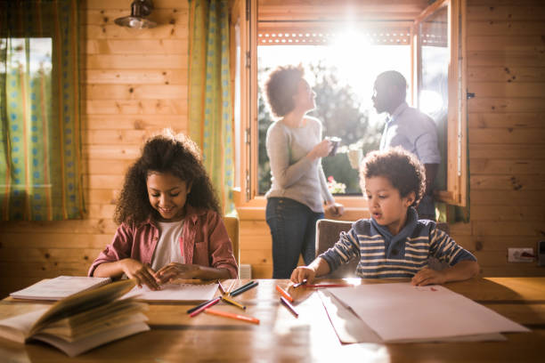 istock Two African American kids enjoying in creative time at home while their parents are drinking coffee. 1142157109