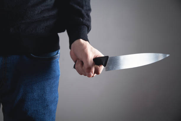istock Caucasian criminal showing knife. 1142159636