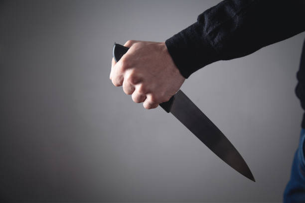 istock Caucasian criminal showing knife. 1142159639