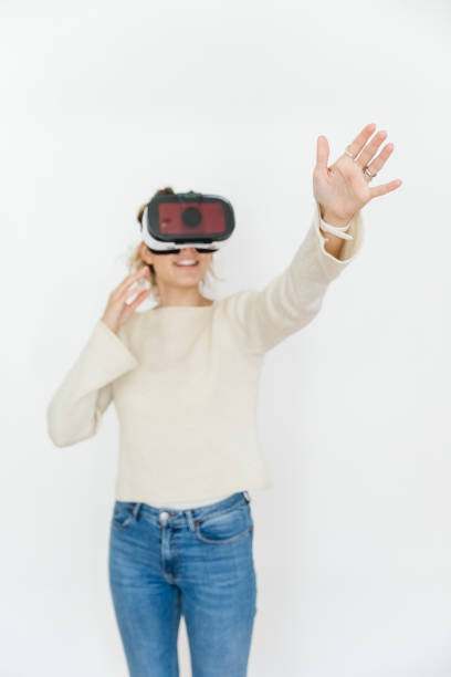 Young Woman Trying VR Glasses, white background. Focus on hand.