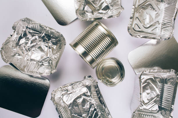 istock Plastic pollution concept. Foil silver container for food, silver cardboards and metal cans on white background, top view. Single-use plastic. New rules to reduce plastic waste, EU directive. We can no longer pollute our planet 1142160221