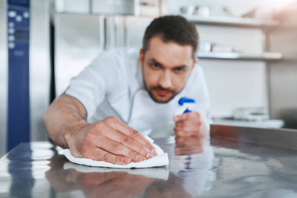 istock Hygienic precautions. Worker in restaurant kitchen cleaning down after service. Selective focus on his hand 1142169889