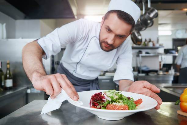 istock Food is our religion. ook preparing dish for serving 1142169966
