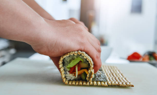 istock How to prepare sushi? Sushi master turns sushi rolls 1142170011
