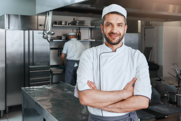 istock We sell flavors. Smiling attractive chef cook with beard standing with hands folded on the kitchen 1142170063