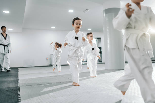 istock Small group of children having training at taekwondo class. All dressed in doboks. White background. 1142171100