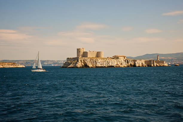 The chateau d'If in Marseille, France. Marseille,France-06 28 2013: A sailing boat passes near the island castle and former prison of the Chateau d'If, located offshore in the Bay of Marseille, southern France. frioul archipelago stock pictures, royalty-free photos & images