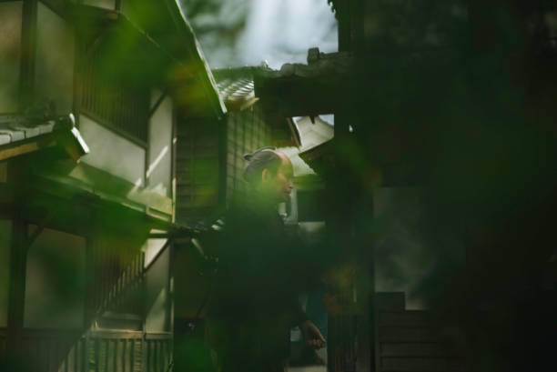 Portrait of a Japanese man walking between buildings.