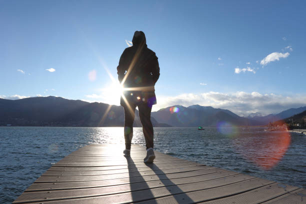Lake, sun and mountains behind