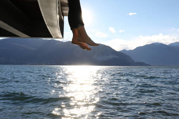 istock Woman dangles feet over dock's edge 1142179719