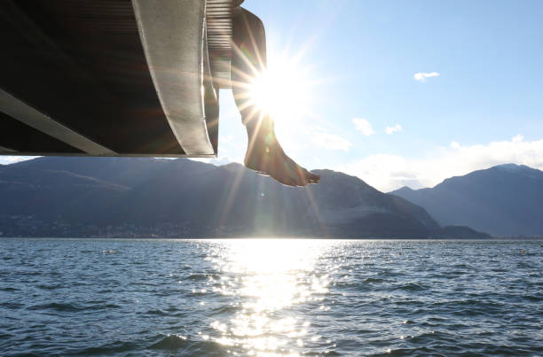 istock Woman dangles feet over dock's edge 1142179732
