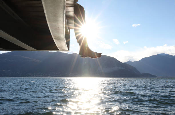 istock Woman dangles feet over dock's edge 1142179735