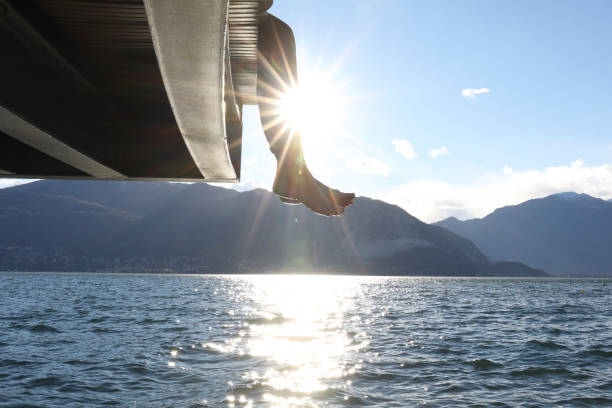 istock Woman dangles feet over dock's edge 1142179754
