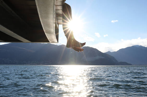 istock Woman dangles feet over dock's edge 1142179756