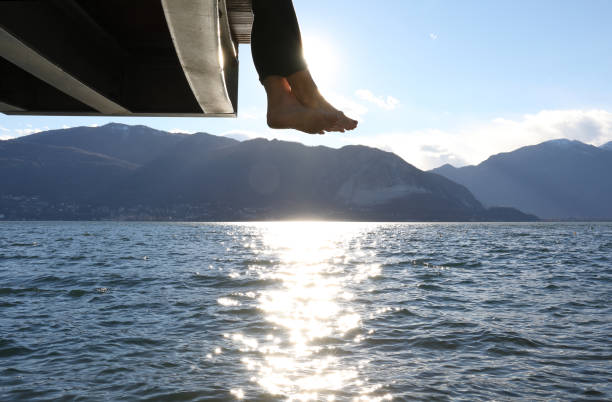 istock Woman dangles feet over dock's edge 1142179769