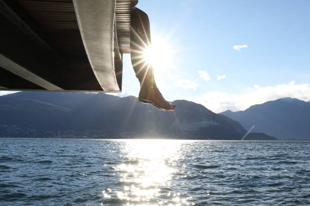 istock Woman dangles feet over dock's edge 1142179774