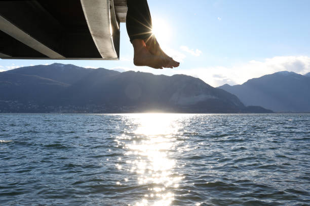 istock Woman dangles feet over dock's edge 1142179782