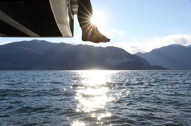 istock Woman dangles feet over dock's edge 1142179840