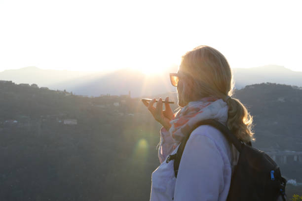 istock Female hiker talks on cellphone at sunset 1142180614