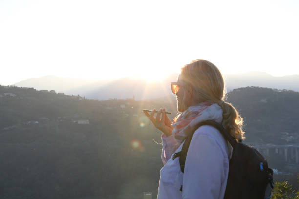 istock Female hiker talks on cellphone at sunset 1142180680