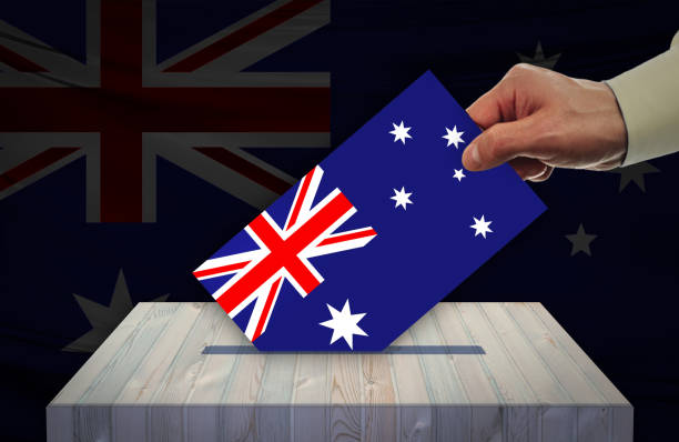 istock Man voting on elections in AUSTRALIA front of flag 1142180958