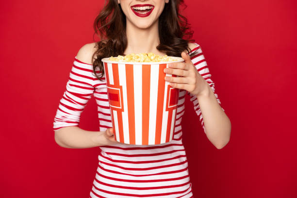 istock Happyyoung lady with big box of pop corn 1142185770