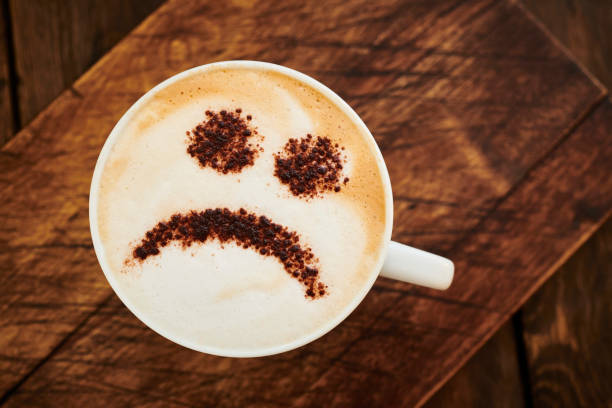 istock Cappuccino Coffee topped with a chocolate unhappy smiley face. 1142185860