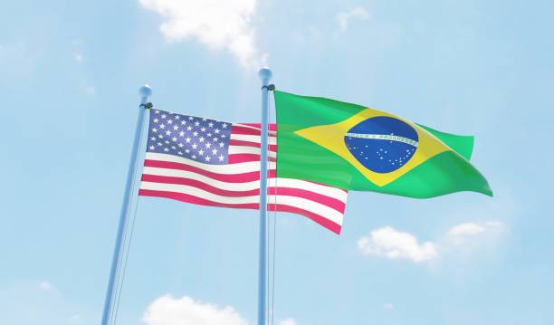 istock Brazil and USA, two flags waving against blue sky 1142186065