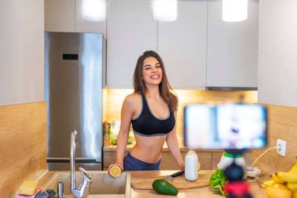 istock Fit young woman making smoothie and looking at camera. 1142186080
