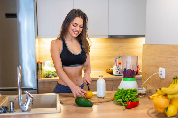 istock Fit smiling young woman preparing healthy fruit juice 1142186890