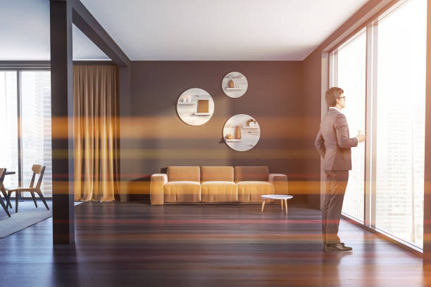 istock Man in gray living room with beige sofa 1142187344
