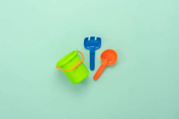 Photo of Table top view decoration kid toys for play sand in holiday background concept.Flat lay colorful item on modern green paper at office desk.Copy space for add text.Creative design pastel tone wallpaper