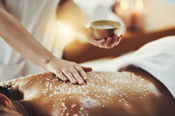 Improved circulation gives skin a natural glow Closeup shot of a woman getting an exfoliating massage at a spa salt character stock pictures, royalty-free photos & images