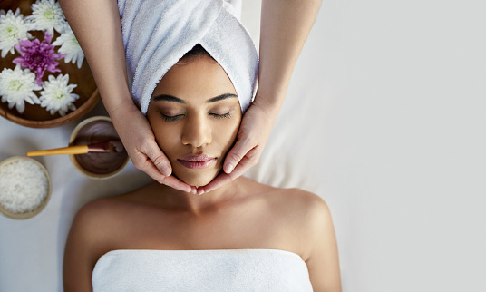 Shot of a young woman getting a facial treatment at a spa