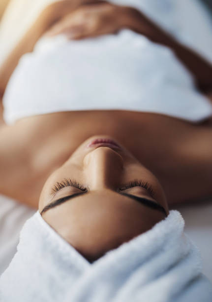 You're in the no-stress zone now Shot of a young woman relaxing on a massage table at a spa woman wrapped in bath towel stock pictures, royalty-free photos & images
