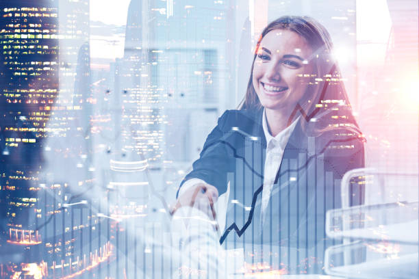 istock Businesswoman shaking hands in office, graph 1142189019