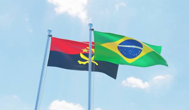 istock Brazil and Angola, two flags waving against blue sky 1142190366