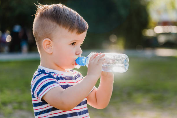 istock handsome boy drinks clear water from a bottle on a sunny day outside 1142190433