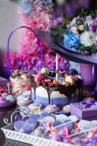istock Beautiful purple cake with macaron and biscuits on the table 1142192410