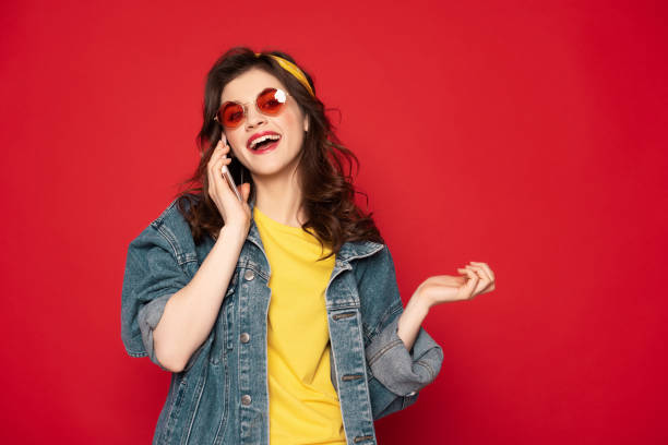 istock Cheerful young girl talking by mobile phone 1142195599