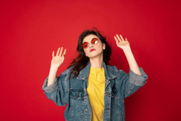 istock Cute hipster girl posing isolated on red 1142195620