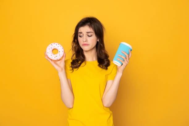 istock Very sad girl looking on donut and coffee 1142195644