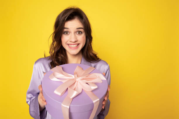 istock Cheerful pretty girl holding festive present box 1142195668
