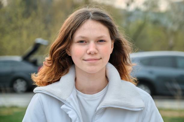 retrato al aire libre de chica adolescente 15 años, chica sonriendo con pelo largo castaño en chaqueta blanca - 13 14 years fotografías e imágenes de stock