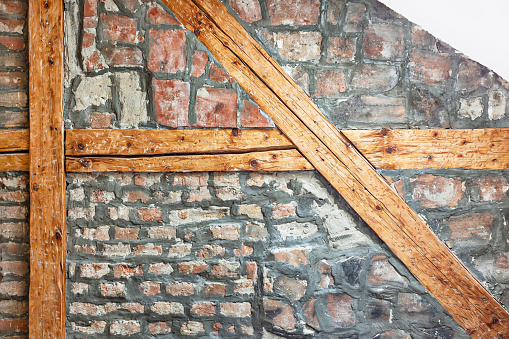 Architectural solution of a wall supporting a roof - wood beams in a brick wall