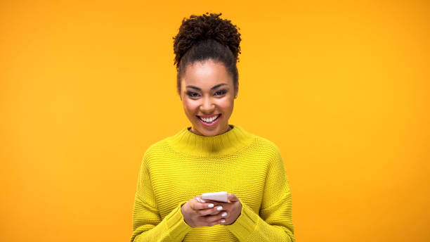 Excited Afro-American lady smiling on camera phone hand, social network message